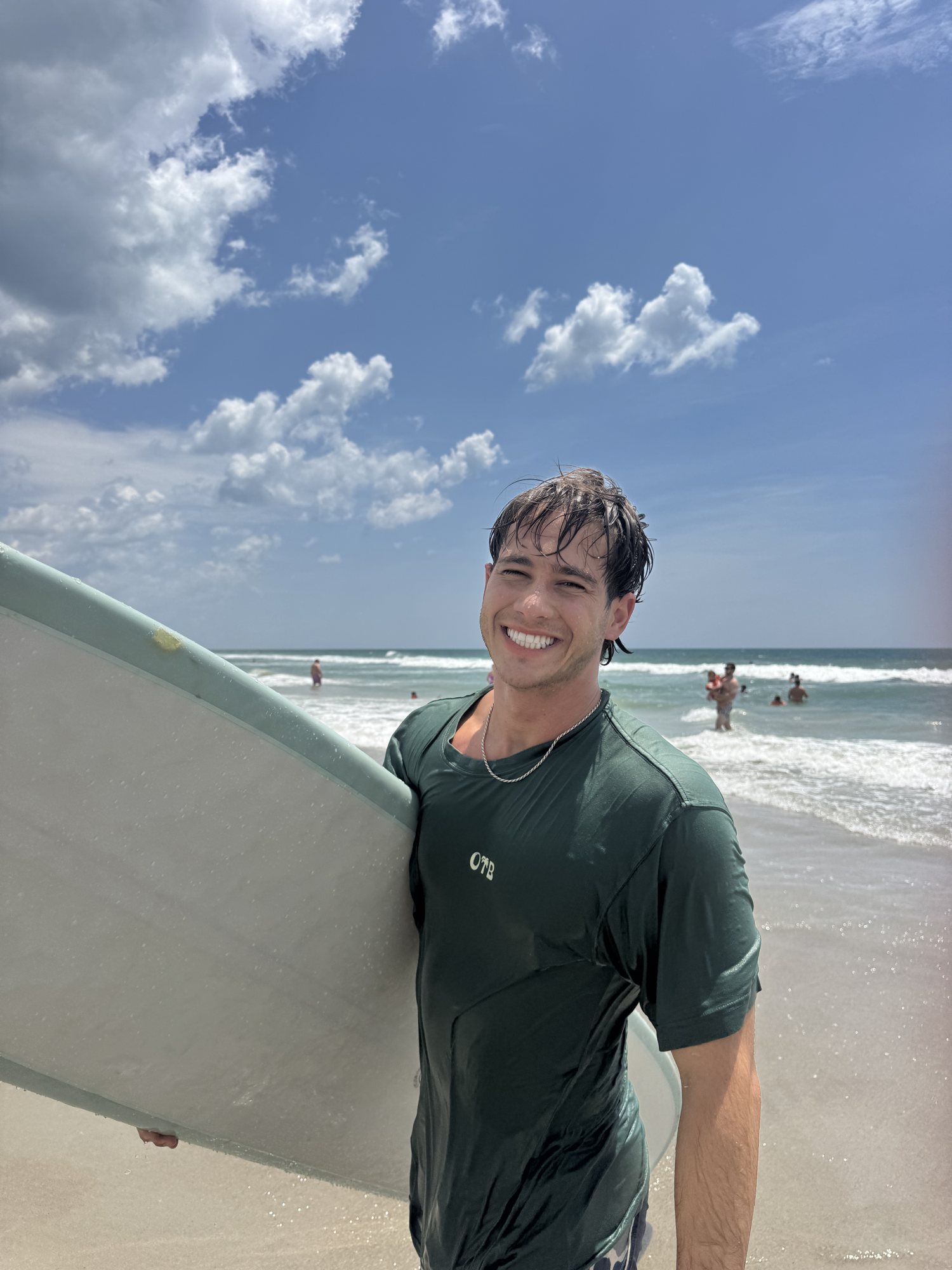 dalen michaels with his surfboard on the beach
